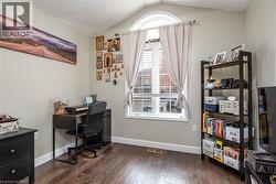 Office space with lofted ceiling and dark wood-type flooring - 