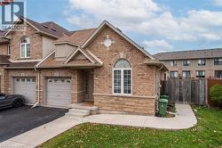 View of front of house with driveway, stone siding, a garage, and a shingled roof - 