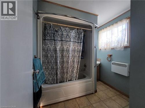 Bathroom featuring shower / tub combo, light tile patterned flooring, and a wall mounted AC - 740 Hillcrest Road, Simcoe, ON - Indoor