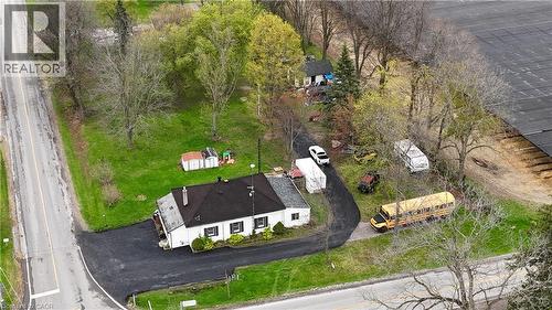 White single-story structure with a dark roof and multiple windows featuring dark shutters - 740 Hillcrest Road, Simcoe, ON - Outdoor With View