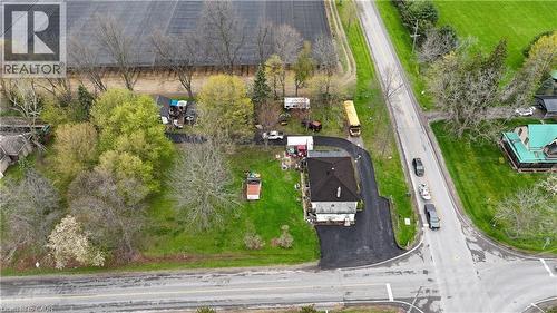 Aerial property overview featuring a dark shingle roof, paved driveway, and mature landscaping - 740 Hillcrest Road, Simcoe, ON - Outdoor With View