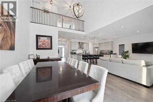 Dining space featuring light wood-style flooring, a high ceiling, and a chandelier - 972 Stonecliffe Walk Unit# 18, Kitchener, ON - Indoor