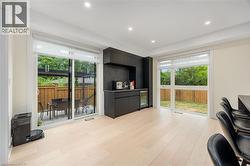 Office area featuring a bar, light wood-style flooring, healthy amount of natural light, beverage cooler, and recessed lighting - 
