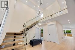 Stairs featuring plenty of natural light, a towering ceiling, hardwood / wood-style flooring, and recessed lighting - 