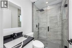 Bathroom with vanity, a marble finish shower, and recessed lighting - 