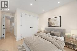 Bedroom with light wood-type flooring, recessed lighting, and a closet - 
