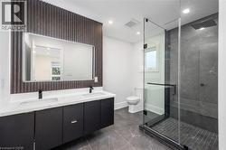 Full bathroom with double vanity, a marble finish shower, recessed lighting, and dark marble finish floors - 