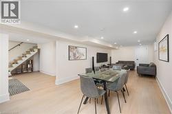 Dining space featuring light wood finished floors, stairs, and recessed lighting - 
