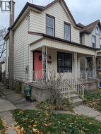 View of front of property featuring a chimney and a porch - 