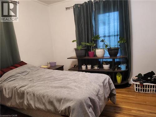 Main Floor Bedroom featuring wood finished floors and ornamental molding - 509 Queensway W, Simcoe, ON - Indoor Photo Showing Bedroom