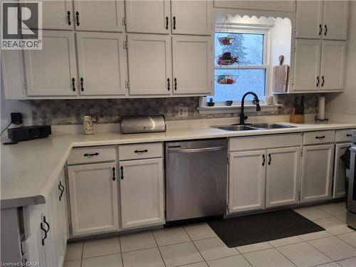 Kitchen with dishwasher, light countertops, white cabinets, and decorative backsplash - 509 Queensway W, Simcoe, ON - Indoor Photo Showing Kitchen With Double Sink