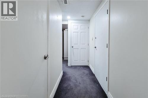 Corridor with dark colored carpet and a textured ceiling - 758 Stone Church Road E, Hamilton, ON - Indoor Photo Showing Other Room