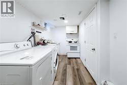 Laundry room featuring light wood-style floors and washer and clothes dryer - 