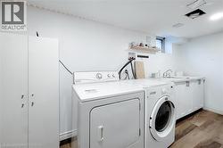 Washroom featuring washing machine and clothes dryer and dark wood-style floors - 