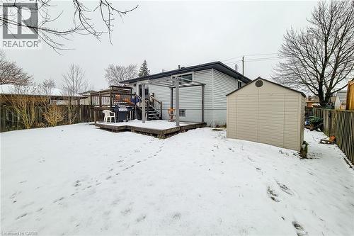 Snow covered rear of property with a storage unit, a wooden deck, and a fenced backyard - 758 Stone Church Road E, Hamilton, ON - Outdoor