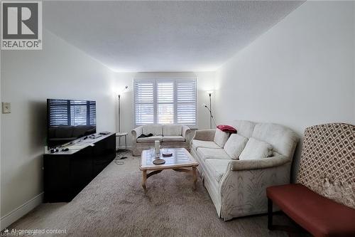 Living area with carpet and a textured ceiling - 758 Stone Church Road E, Hamilton, ON - Indoor Photo Showing Living Room