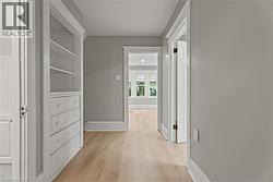 Hallway with light wood-style floors and baseboards - 