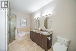 Full bathroom featuring a bath, double vanity, a stall shower, and light tile patterned floors - 