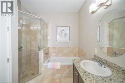 Full bathroom featuring vanity, a shower stall, and a garden tub - 