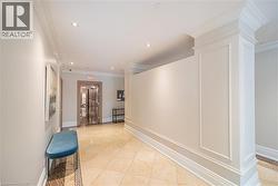 Hallway featuring light tile patterned flooring, crown molding, decorative columns, and recessed lighting - 