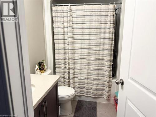 Bathroom with vanity, light tile patterned floors, and shower / bath combo - 65 Old School Trail Unit# 36, Welland, ON - Indoor Photo Showing Bathroom