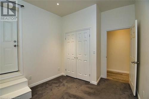 Unfurnished bedroom featuring a closet, baseboards, and dark carpet - 329 King Street E Unit# 3, Hamilton, ON - Indoor Photo Showing Other Room