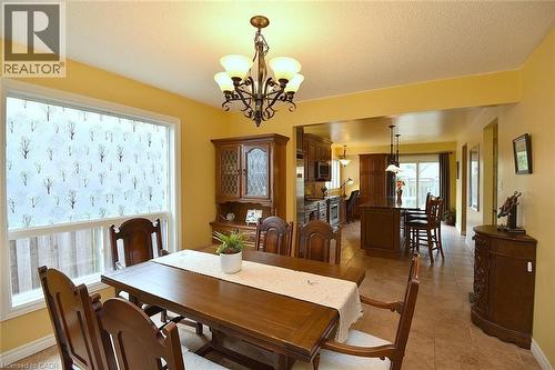 Dining area with a textured ceiling, a chandelier, and light tile patterned floors - 43 Niska Drive, Waterdown, ON - Indoor Photo Showing Dining Room
