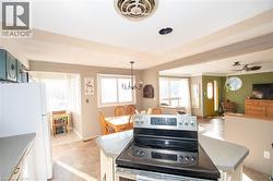 Kitchen featuring electric range, freestanding refrigerator, a ceiling fan, and open floor plan - 