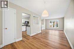 Unfurnished dining area with light wood-style flooring and baseboards - 