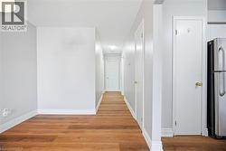 Hallway with light wood-style flooring, attic access, and a textured ceiling - 