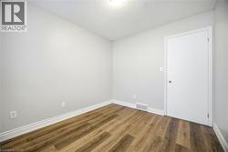 Empty room featuring wood finished floors and a textured ceiling - 