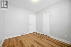 Unfurnished bedroom with a textured ceiling, wood finished floors, and a closet - 