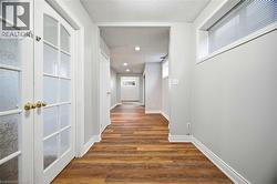 Hallway with light wood-style floors, french doors, and recessed lighting - 