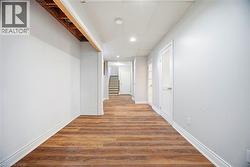 Hall with stairs, wood finished floors, and recessed lighting - 