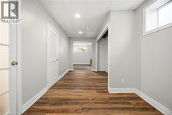 Hallway with dark wood-type flooring and recessed lighting - 