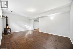 Unfurnished living room with a wood stove and dark wood-style floors - 