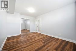 Spare room with dark wood-style flooring and baseboards - 
