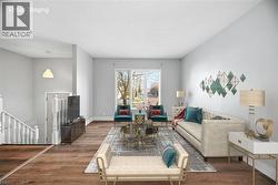 Living room featuring a textured ceiling, stairs, and wood finished floors - 