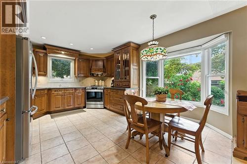 Custom Maple Kitchen stainless steel appliances, light tile patterned floors, and glass insert cabinets - 3 Atkins Drive, Hamilton, ON - Indoor Photo Showing Dining Room