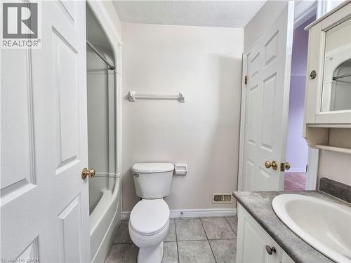 Bathroom with vanity, bathtub / shower combination, a textured ceiling, and light tile patterned floors - 132 Udvari Crescent Unit# 3, Kitchener, ON - Indoor Photo Showing Bathroom