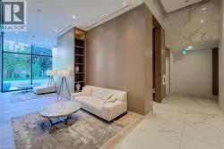 Living room featuring floor to ceiling windows, light marble finish floors, recessed lighting, built in features, and a towering ceiling - 