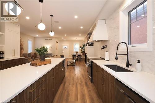 Kitchen with tasteful backsplash, appliances with stainless steel finishes, custom exhaust hood, dark brown cabinets, and recessed lighting - 238 Eagle Street S, Cambridge, ON - Indoor Photo Showing Kitchen With Upgraded Kitchen