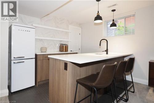 Kitchen featuring freestanding refrigerator, open shelves, light countertops, and hanging light fixtures - 238 Eagle Street S, Cambridge, ON - Indoor Photo Showing Kitchen