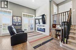Living area featuring stairway, wood finished floors, french doors, and wood walls - 
