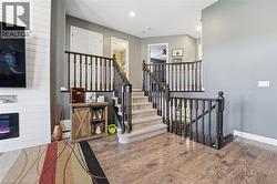 Staircase with wood finished floors, a fireplace, and recessed lighting - 