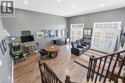 Living area with french doors, wood finished floors, recessed lighting, and a towering ceiling - 