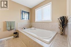 Bathroom with light tile patterned flooring and a bath - 