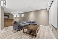 Living area with light wood-type flooring and recessed lighting - 