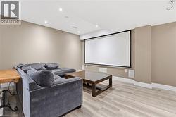 Home theater room with recessed lighting and light wood-style flooring - 