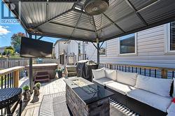 Wooden deck featuring area for grilling and a hot tub - 